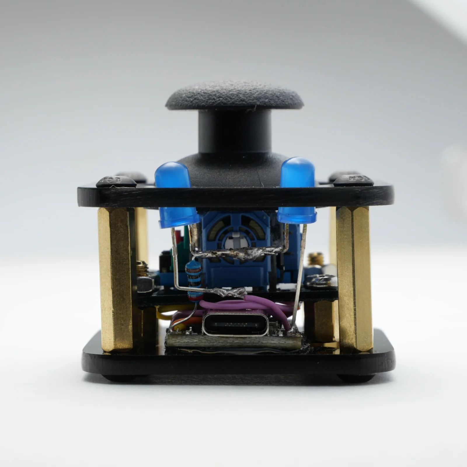 Earlier black acrylic pipSqueak design, showing its joystick, blue LEDs, and USB-C connector