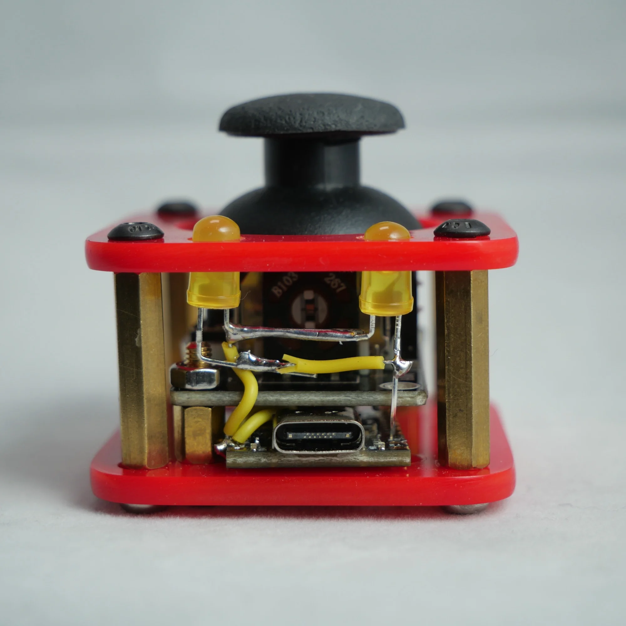 Earlier red acrylic pipSqueak design, with yellow LEDs, exposed wiring, and brass standoffs
